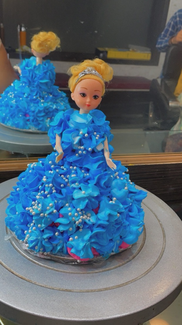 A princess doll cake with a frosted blue ruffled gown