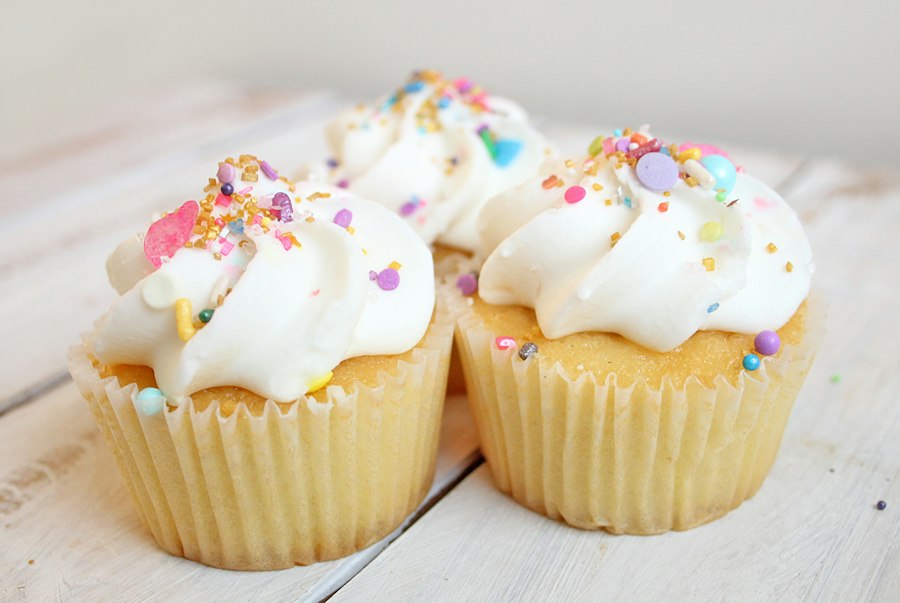 Vanilla cupcakes with swirls of frosting and sprinkles